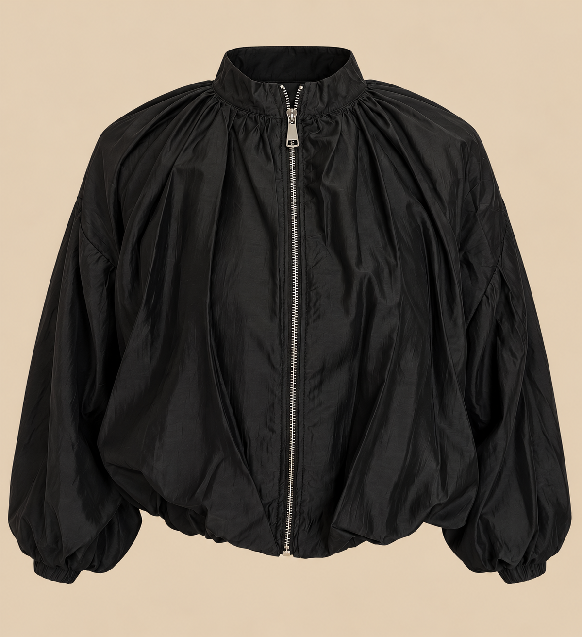 Chaqueta Oslo negra de cremallera y fruncidos sobre fondo beige