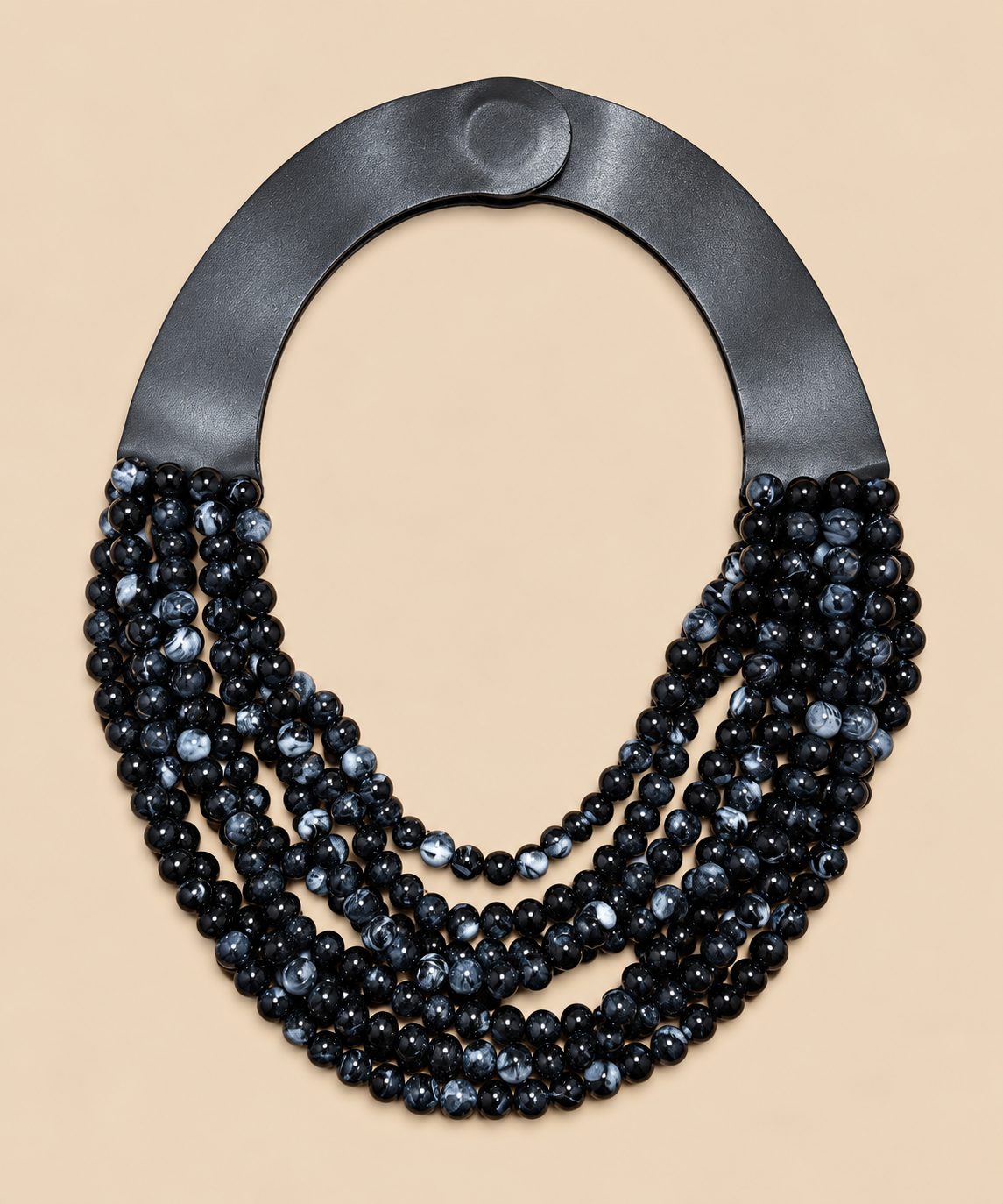 Collar Marrakech negro y gris jaspeado con cierre imantado sobre fondo beige