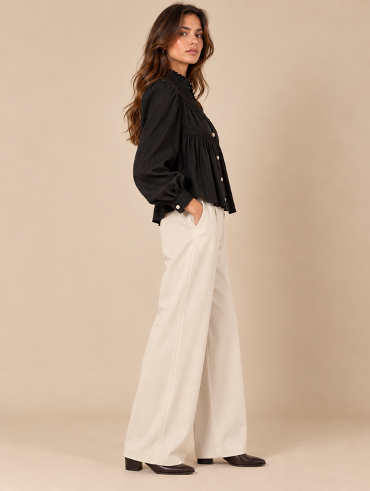 Blusa negra con encaje y detalles fruncidos RYRTEEN puesta por modelo, vista lateral