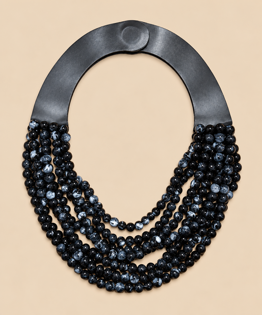 Collar Marrakech negro y gris jaspeado con cierre imantado sobre fondo beige