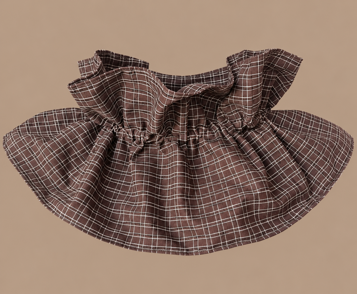 Cuello postizo de cuadros chocolate con volante sobre fondo beige